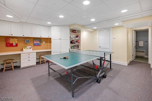 recreation room with radiator heating unit, baseboard heating, dark colored carpet, and built in study area