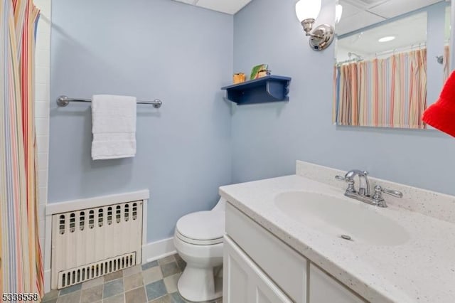 bathroom featuring radiator, baseboards, toilet, and vanity