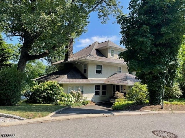 view of front of home featuring a chimney and stucco siding