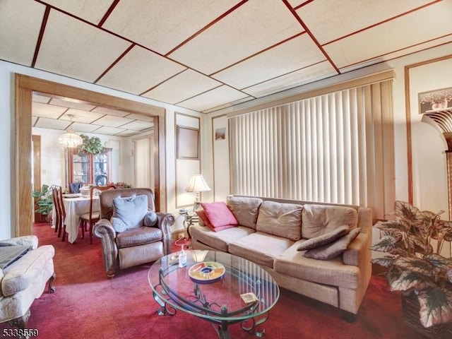 carpeted living room with a notable chandelier