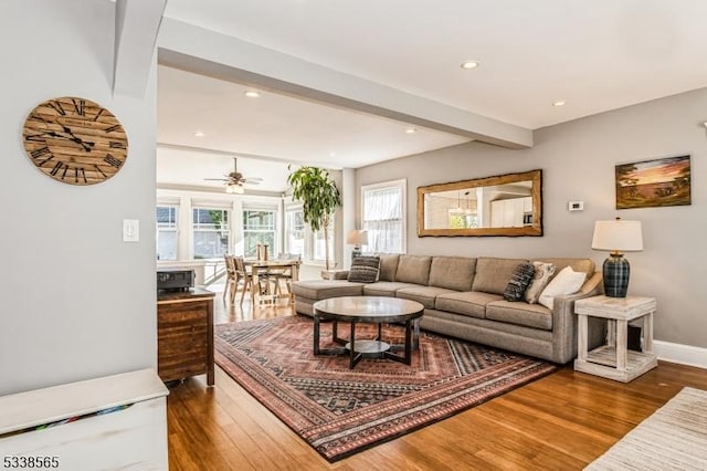 living room featuring recessed lighting, beamed ceiling, baseboards, and wood finished floors