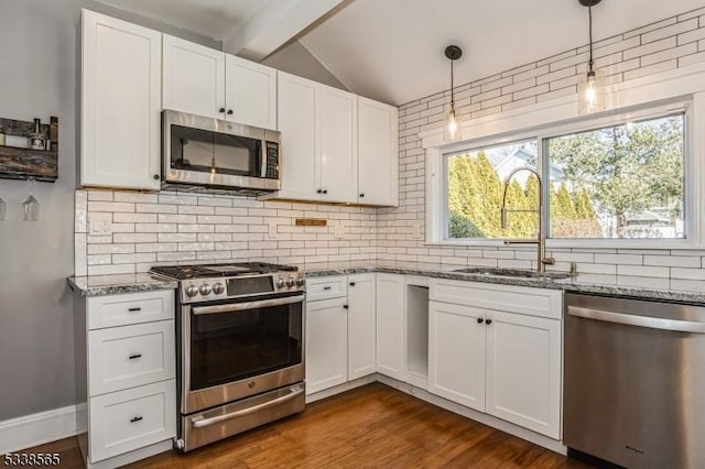 kitchen featuring vaulted ceiling with beams, stainless steel appliances, stone countertops, and a sink