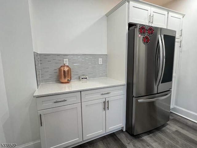 kitchen featuring stainless steel refrigerator, white cabinetry, dark hardwood / wood-style floors, and tasteful backsplash