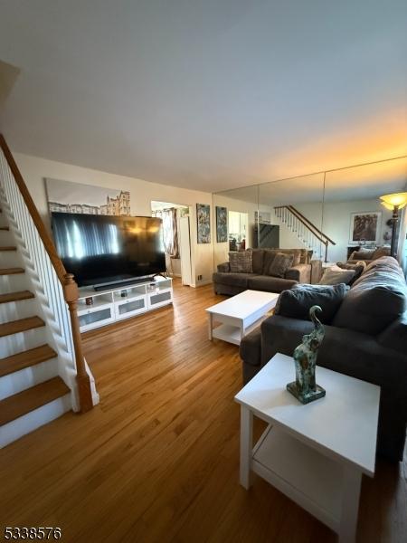 living area featuring stairs and wood finished floors