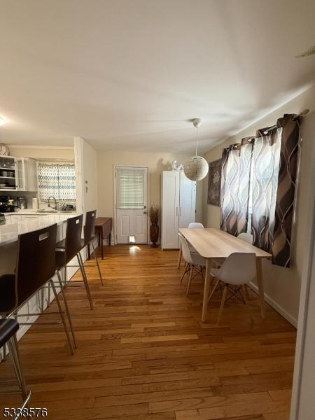 dining space with light wood finished floors and baseboards