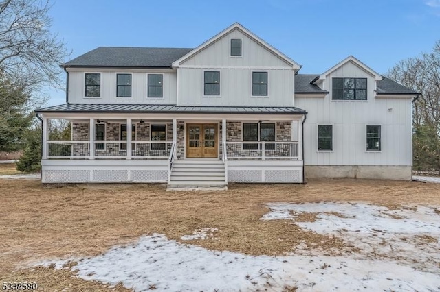 modern inspired farmhouse featuring covered porch, board and batten siding, and a standing seam roof