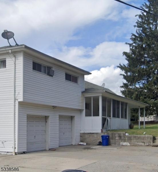 view of front of house featuring a garage and a sunroom