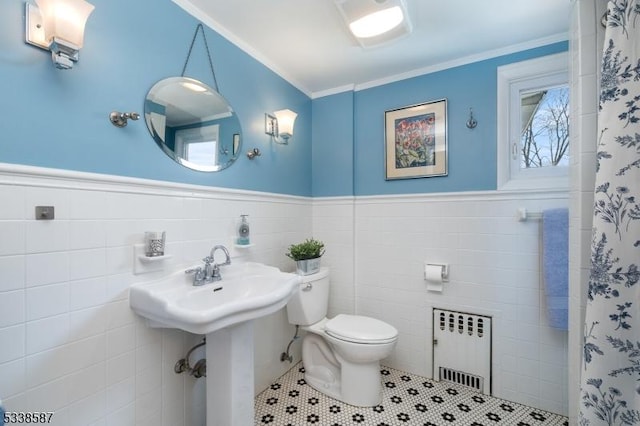 full bathroom with crown molding, radiator, toilet, wainscoting, and tile patterned flooring