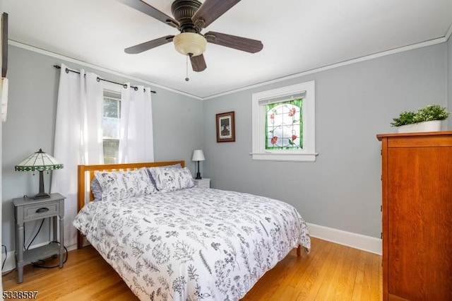 bedroom featuring ornamental molding, wood finished floors, a ceiling fan, and baseboards