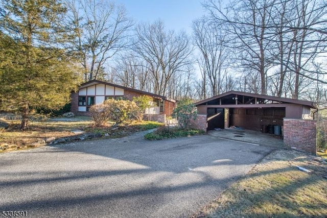 view of front of house featuring a carport, aphalt driveway, and brick siding