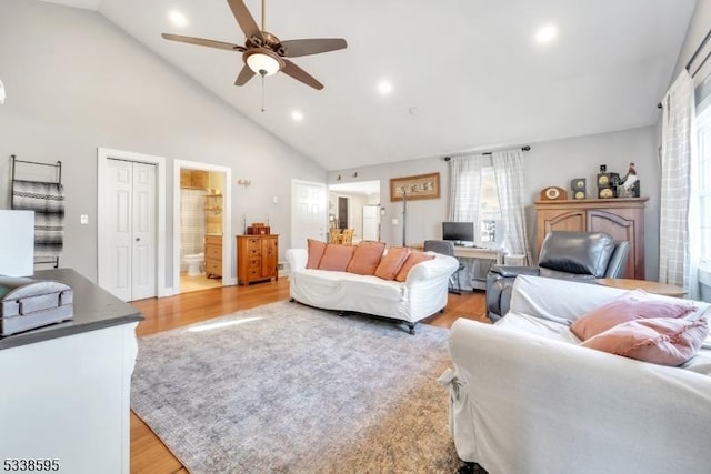 living room with high vaulted ceiling, light hardwood / wood-style flooring, ceiling fan, and a baseboard heating unit