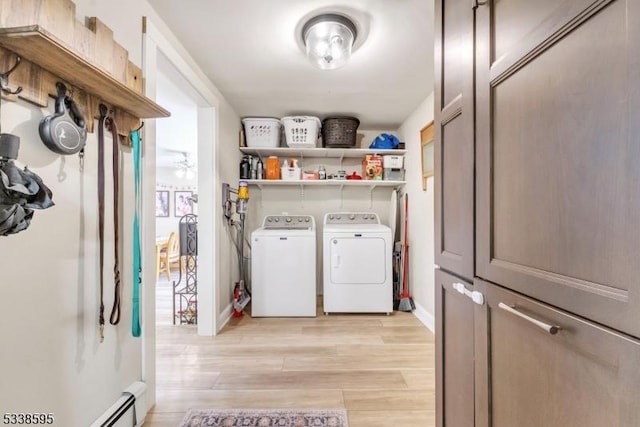 laundry room with a baseboard heating unit, washing machine and clothes dryer, and light hardwood / wood-style floors