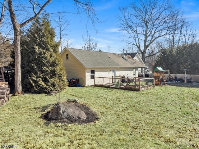 rear view of property featuring a yard and a playground