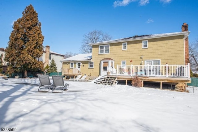 snow covered rear of property featuring a wooden deck