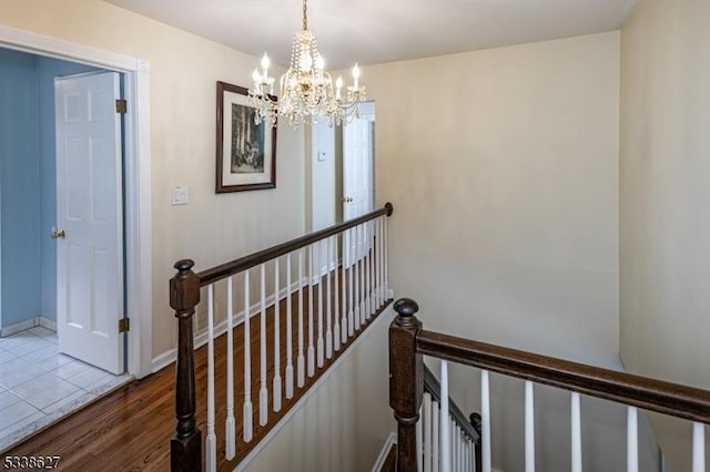 stairway featuring hardwood / wood-style flooring and a chandelier