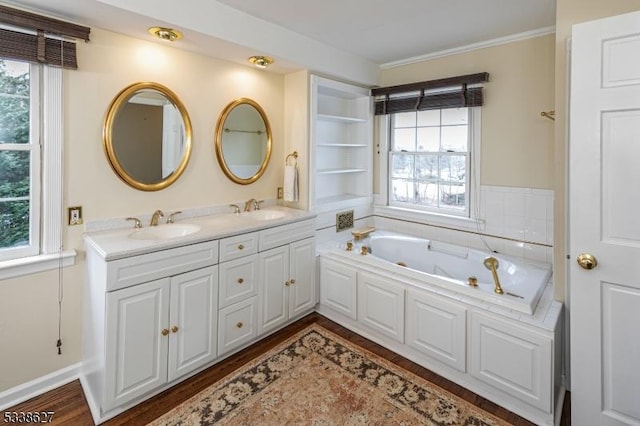 bathroom featuring tiled bath, plenty of natural light, vanity, and hardwood / wood-style floors