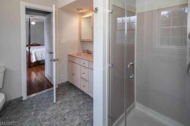 bathroom featuring vanity, a shower with shower door, and toilet