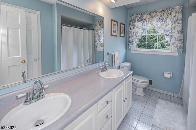 bathroom with toilet, tile patterned flooring, and vanity