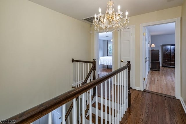 corridor with a notable chandelier and dark hardwood / wood-style flooring