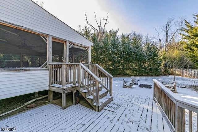 snow covered deck with an outdoor fire pit and a sunroom