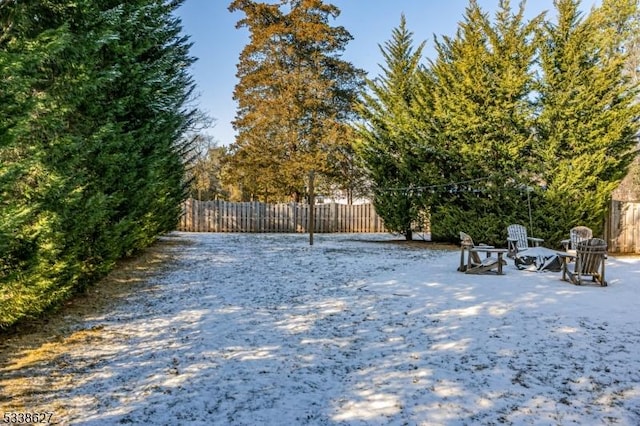 snowy yard with an outdoor fire pit