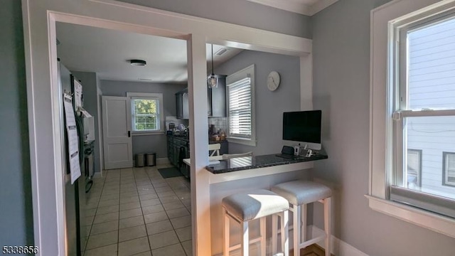 kitchen with baseboards, a breakfast bar, and light tile patterned flooring