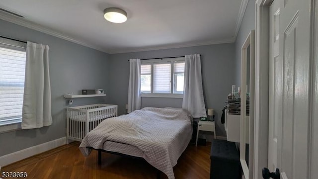 bedroom with baseboards, visible vents, radiator heating unit, ornamental molding, and wood finished floors