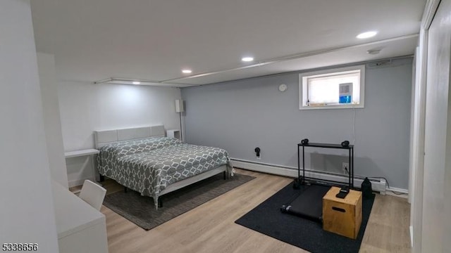 bedroom featuring baseboard heating, wood finished floors, and recessed lighting