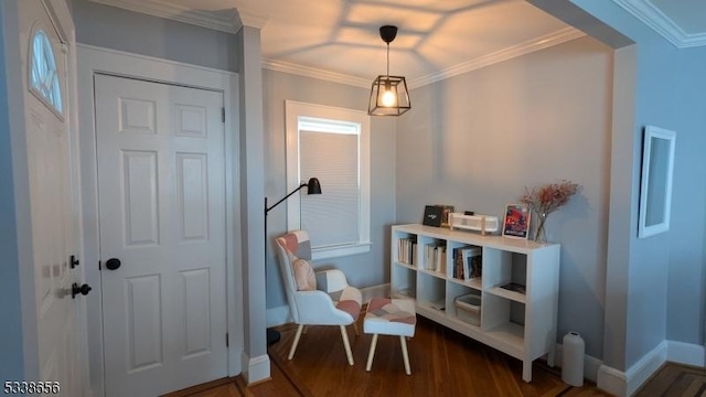 living area with crown molding, baseboards, and wood finished floors