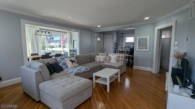 living area featuring plenty of natural light, wood finished floors, and crown molding