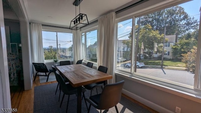 sunroom / solarium with a chandelier