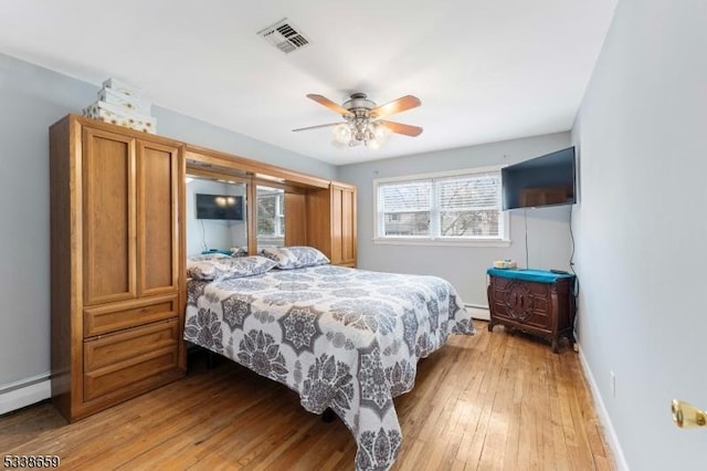 bedroom featuring ceiling fan, light hardwood / wood-style floors, and baseboard heating