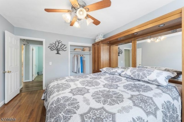 bedroom with dark wood-type flooring, a closet, and ceiling fan