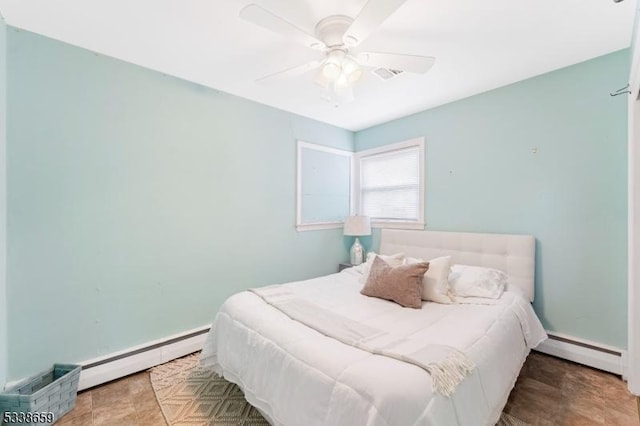 bedroom with ceiling fan and a baseboard heating unit