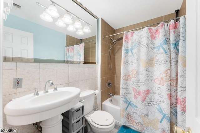 full bathroom featuring sink, tile walls, shower / bathtub combination with curtain, and toilet