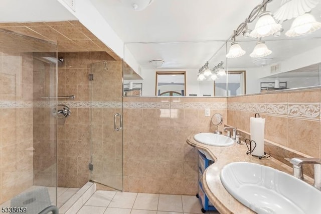 bathroom featuring tile patterned floors, a shower with door, tile walls, and vanity