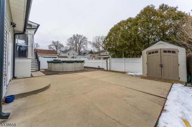 view of patio with a storage shed and a covered pool