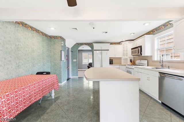 kitchen featuring appliances with stainless steel finishes, a center island, sink, and white cabinets