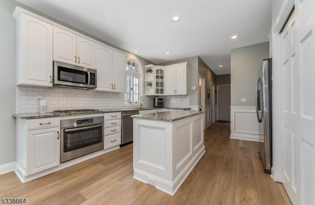 kitchen with light wood-style floors, white cabinetry, and stainless steel appliances