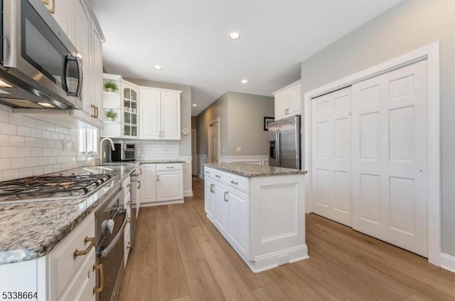 kitchen featuring white cabinets, light wood-style floors, and stainless steel appliances