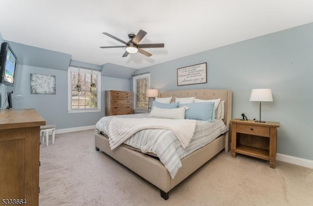 bedroom with light carpet, lofted ceiling, a ceiling fan, and baseboards