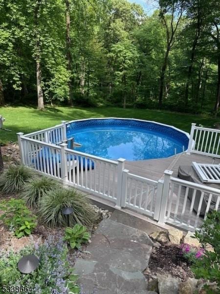 outdoor pool featuring a lawn