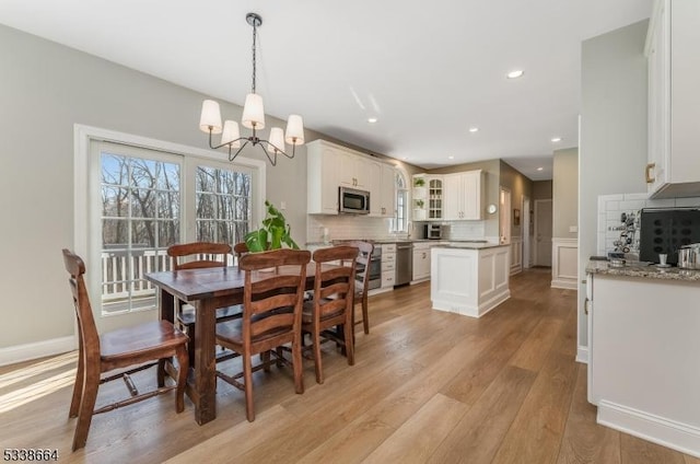 dining area with a chandelier, recessed lighting, baseboards, and light wood finished floors