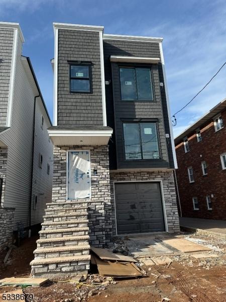 view of front of home featuring a garage and stone siding