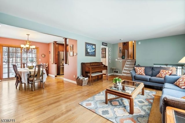 living room with a notable chandelier and light hardwood / wood-style floors