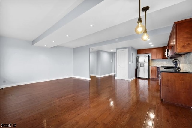 kitchen with hanging light fixtures, appliances with stainless steel finishes, dark hardwood / wood-style floors, and backsplash