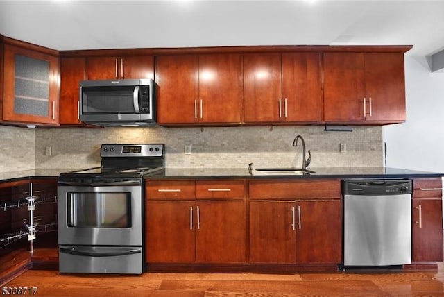 kitchen featuring tasteful backsplash, sink, hardwood / wood-style flooring, and stainless steel appliances