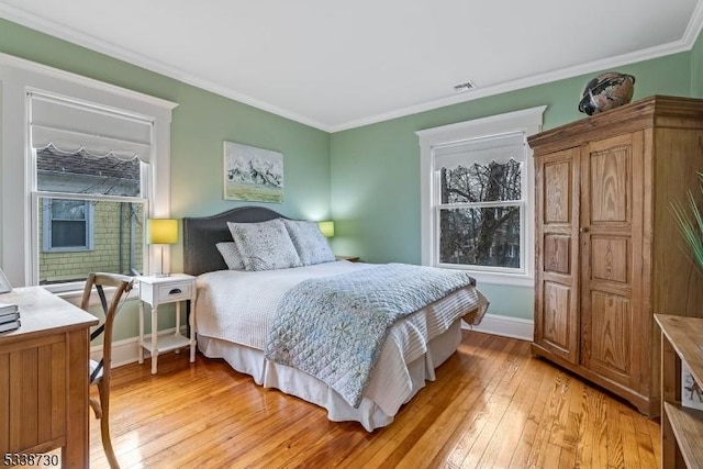 bedroom featuring light hardwood / wood-style flooring and crown molding