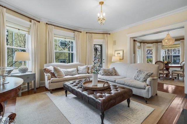 living room featuring crown molding, an inviting chandelier, and wood-type flooring