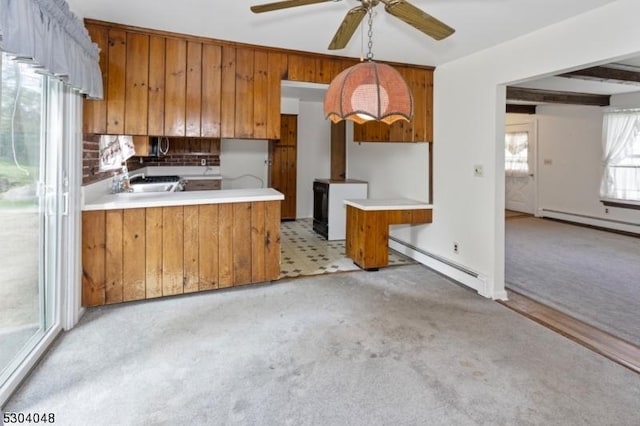 kitchen featuring light carpet, a baseboard heating unit, decorative light fixtures, and kitchen peninsula